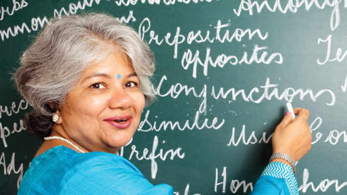 a woman writing on a chalk board