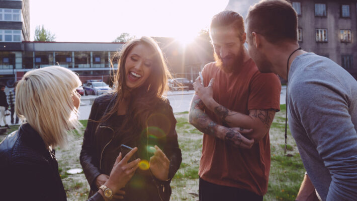 four friends gather in a park outside