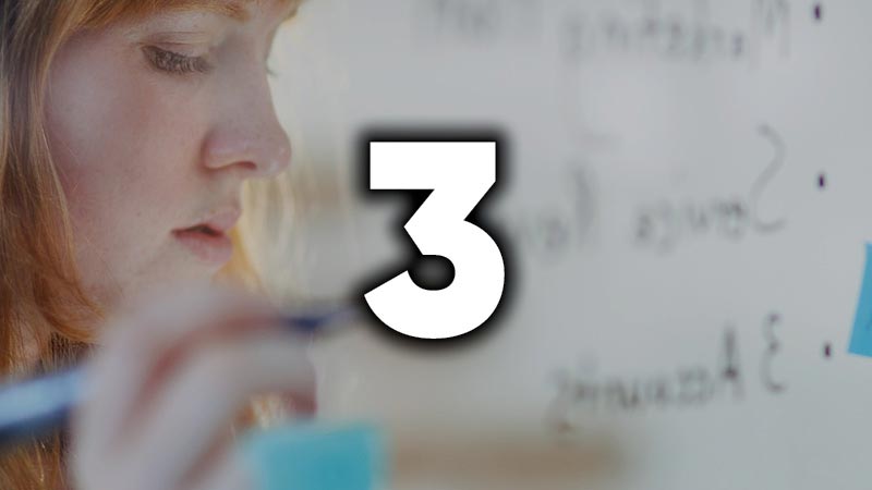 a woman writing on a white board