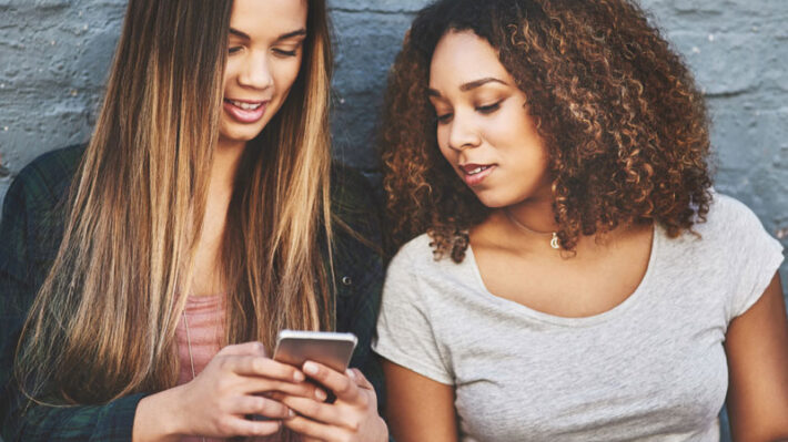 two girls looking at a cellphone