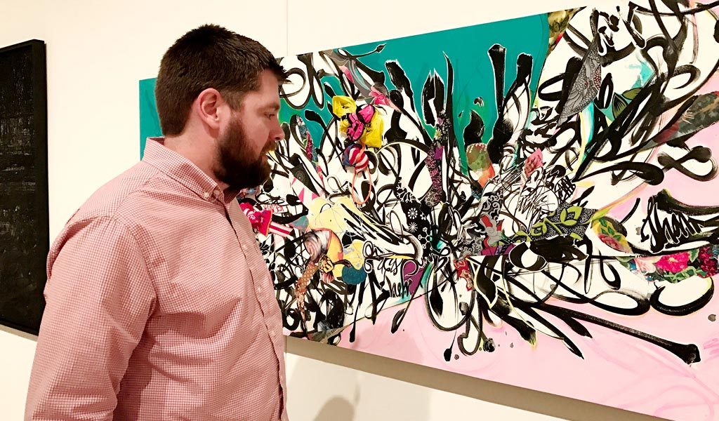 a man looking at canvas art