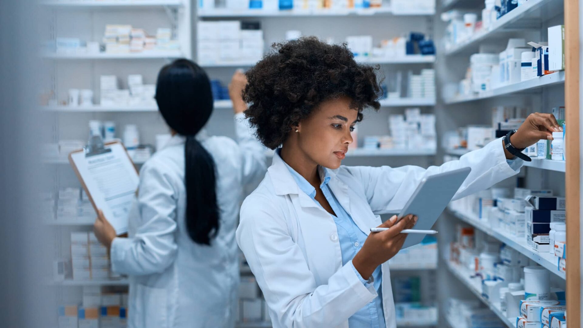 two women pharmacists locating medicine in the stock room