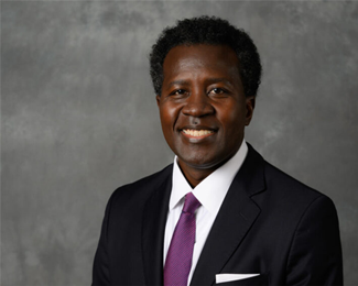 A headshot of W. Keith Robinson. A black man smiling with short curly hair. 