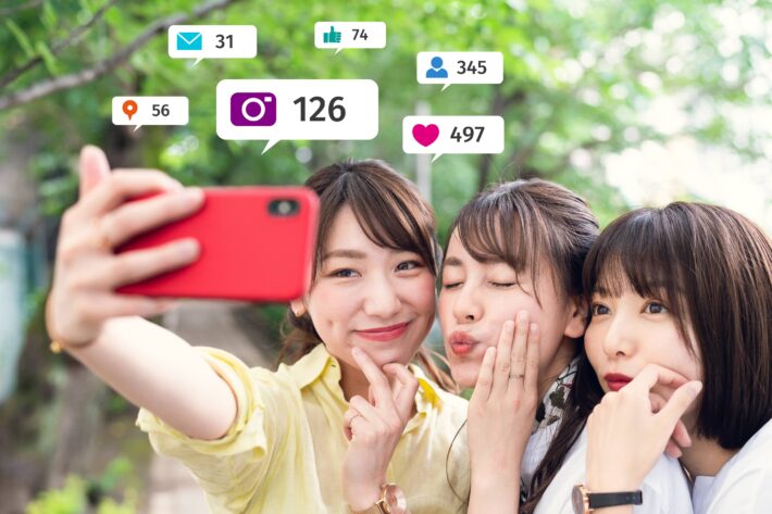 Three minority women taking a group selfie