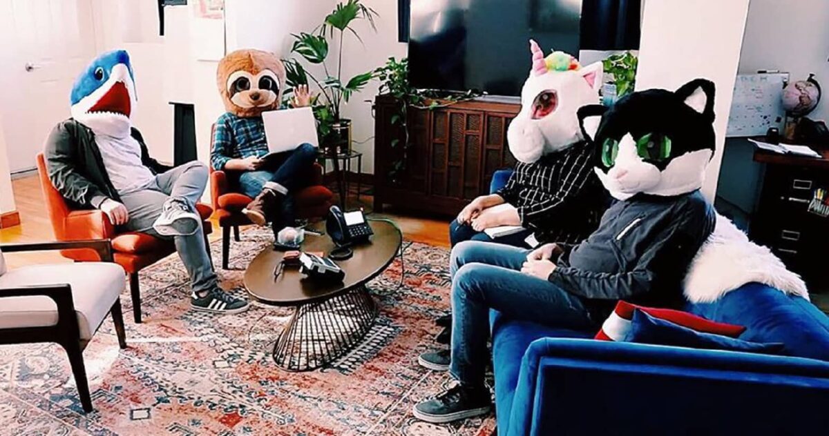 5 people wearing mascot helmets sitting in a living room 