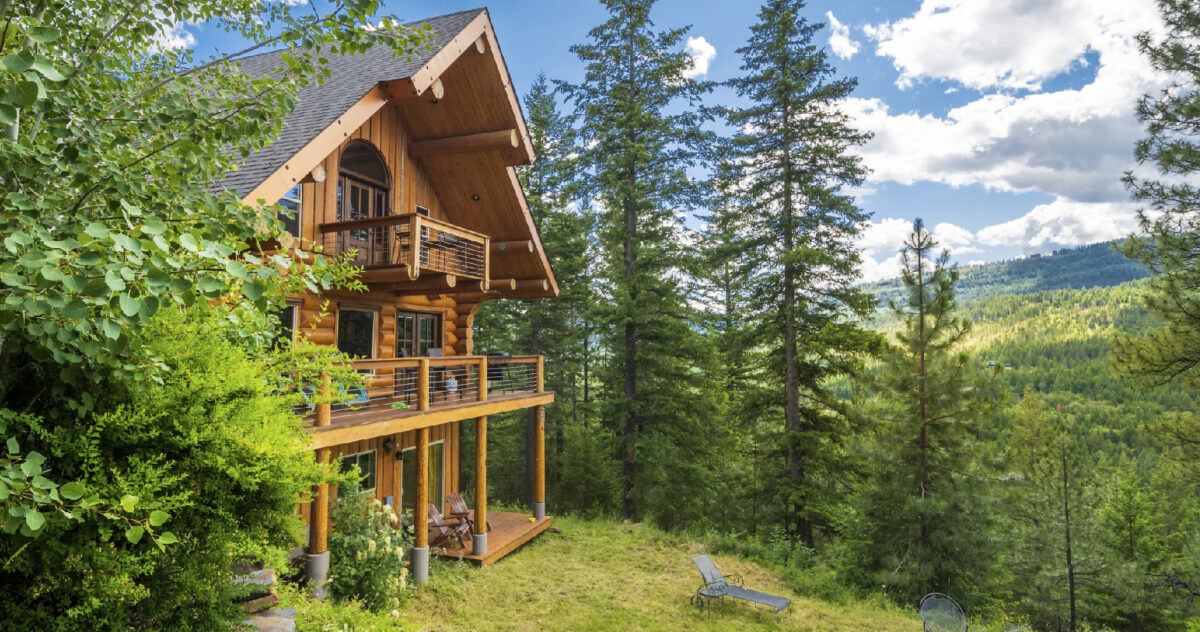 exterior: a log cabin in the woods in daytime. 