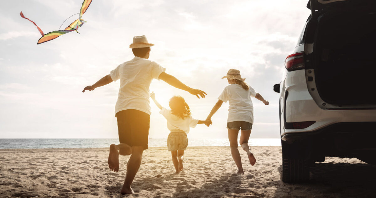 a family of three running out towards the beach 