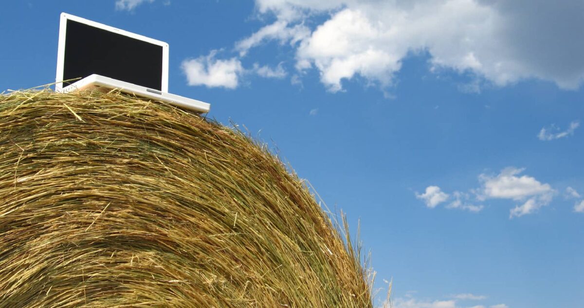 A laptop balanced on a haystack.