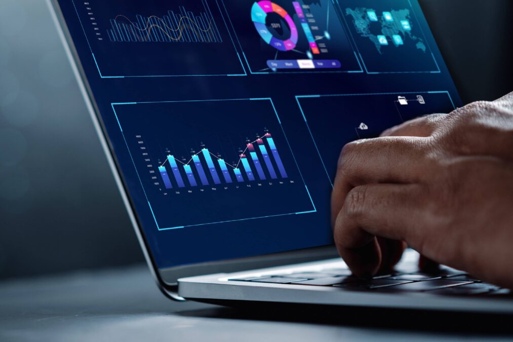 hands are typing on a caption screen. The screen shows data in the form of a graph and pie chart.