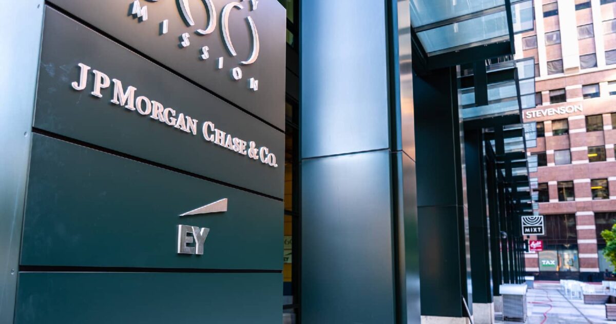 "JP Morgan Chase & Co." is printed on the front of a building in a downtown setting
