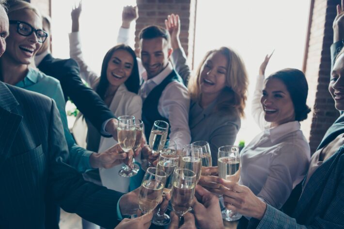 a staff of people cheering champagne glasses