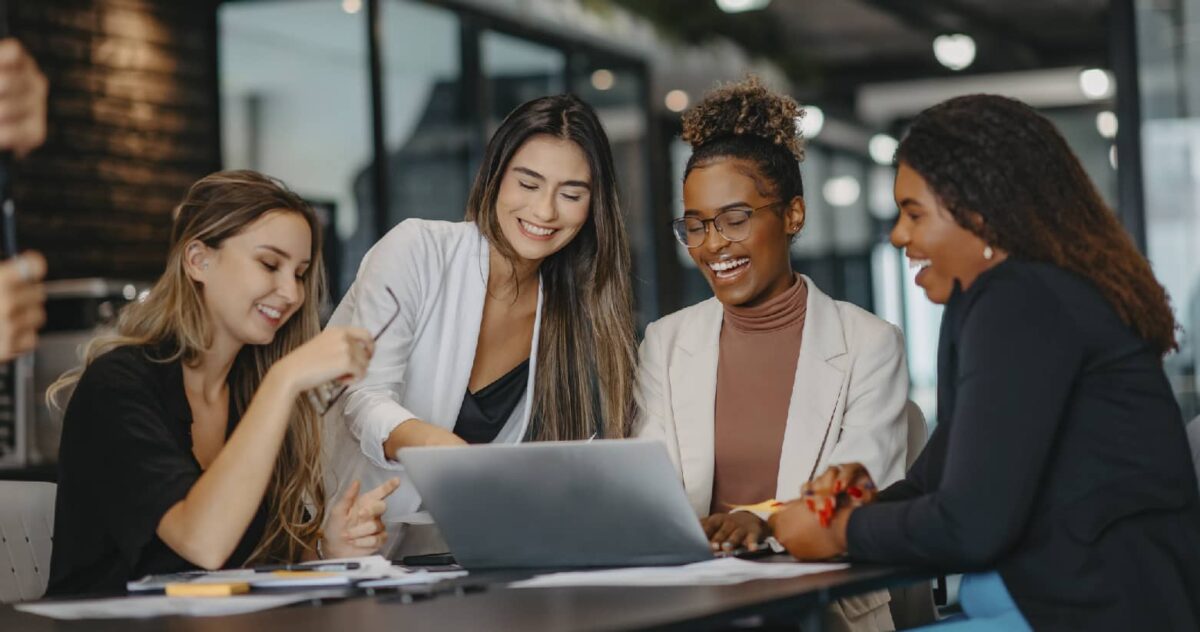 A team of people smiling and working together, representing SEO's value for operations and other concerns for C-Suite individuals