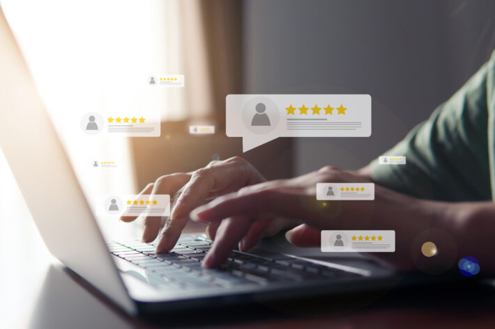 hands typing on keyboard with customer reviews floating on screen