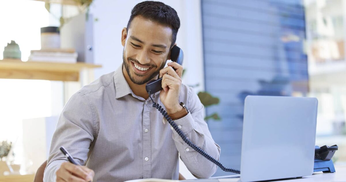 A man smiling as he speaks on the phone