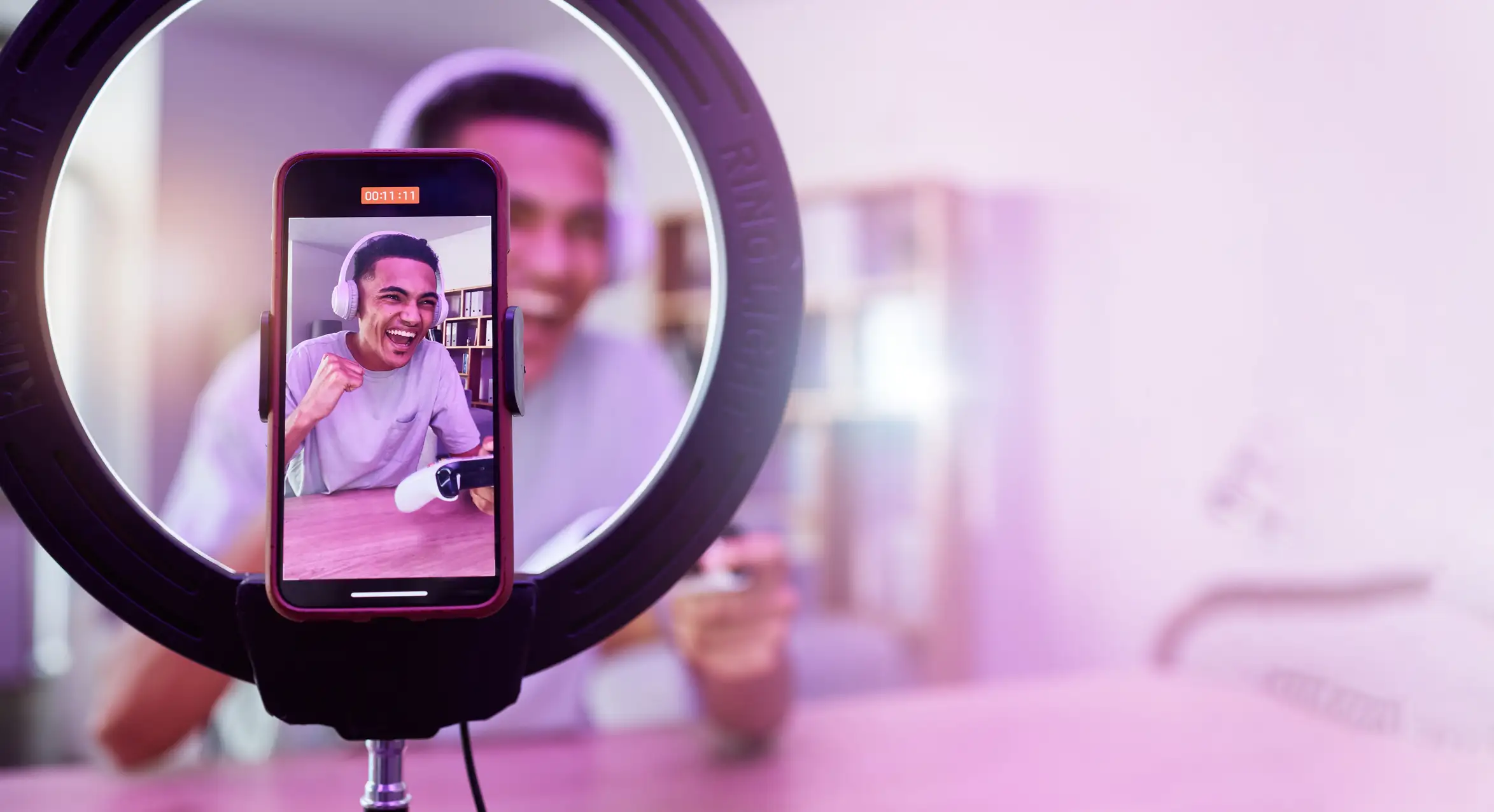 Influencer recording themselves with phone in a ring light.