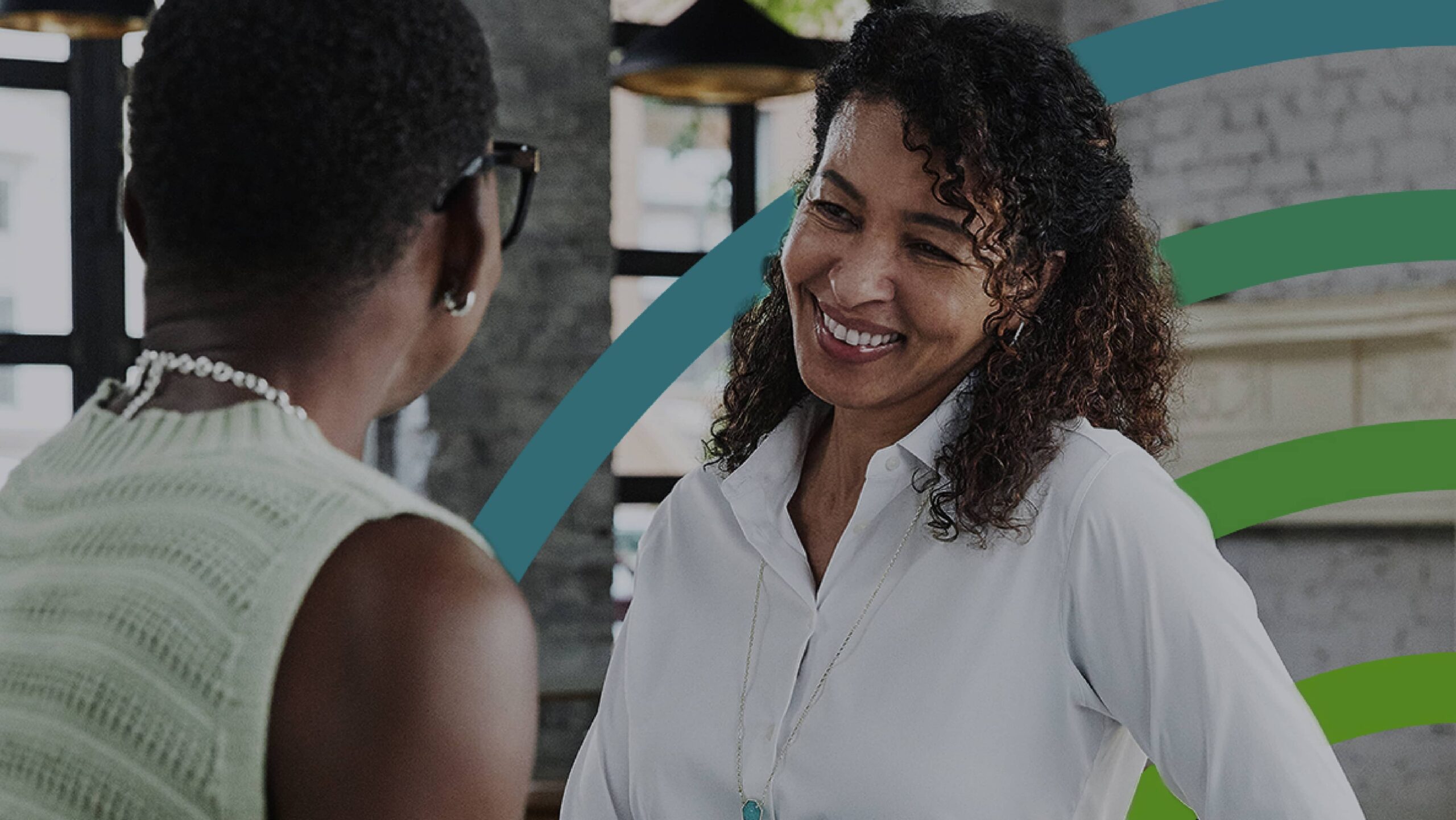 Two Black women smiling at each other