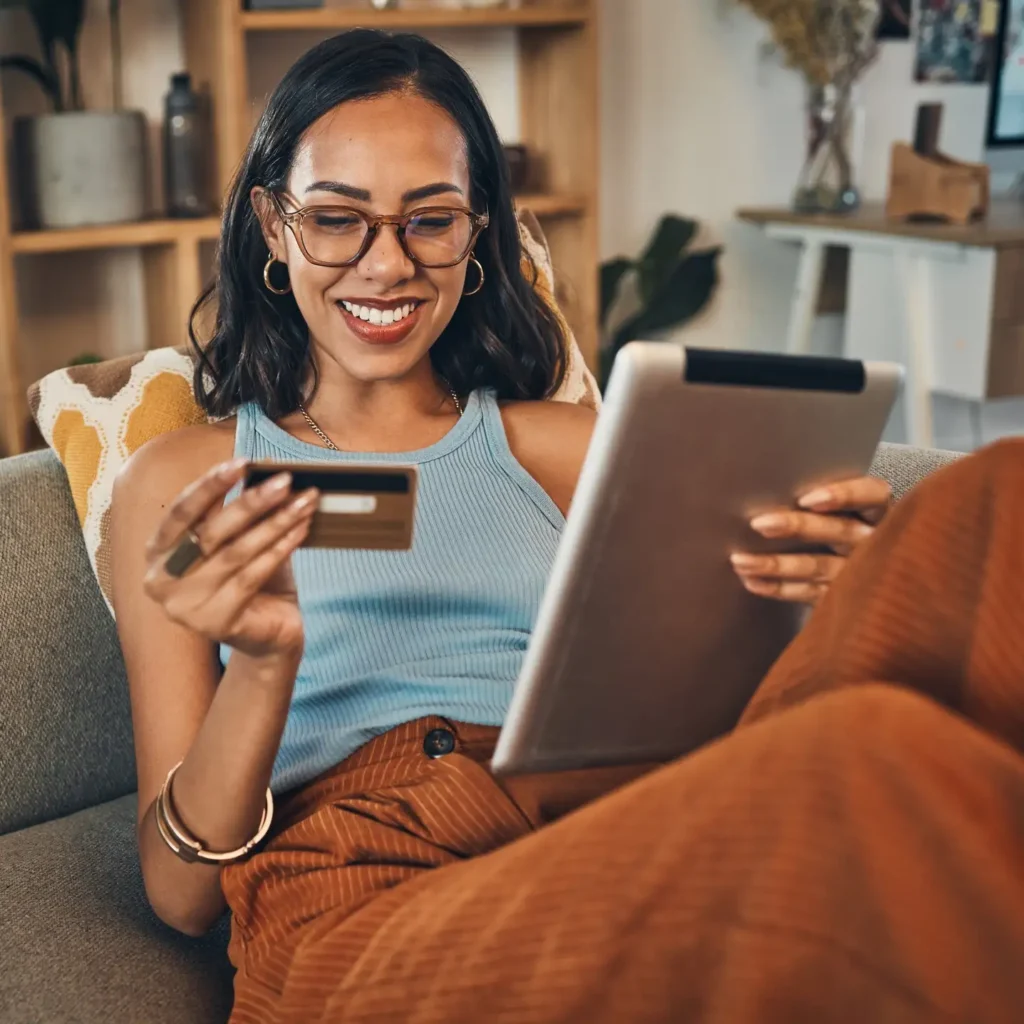 Woman holding tablet and credit card.