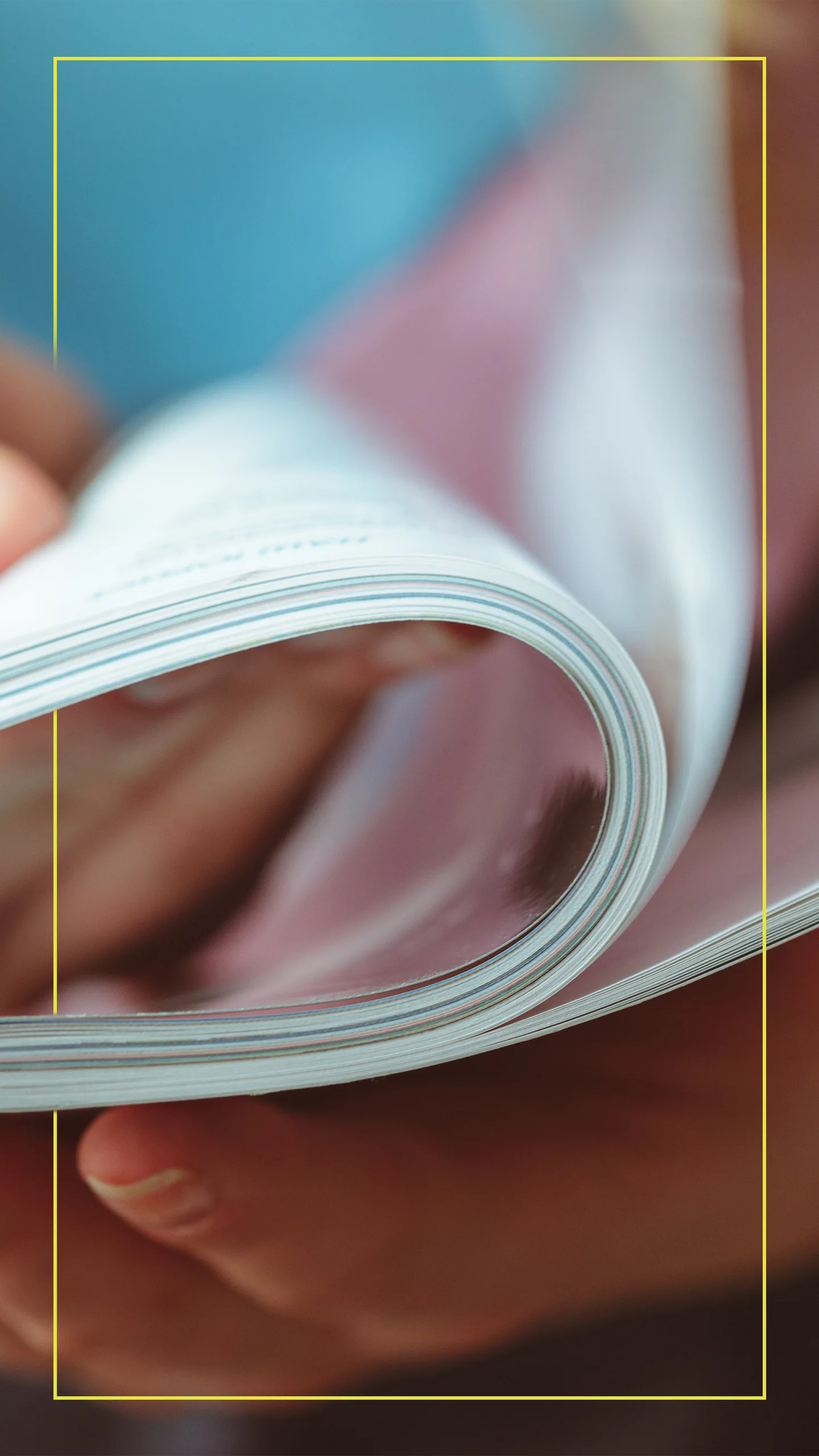 Person turning pages in a printed magazine, illustrating engagement with print media.
