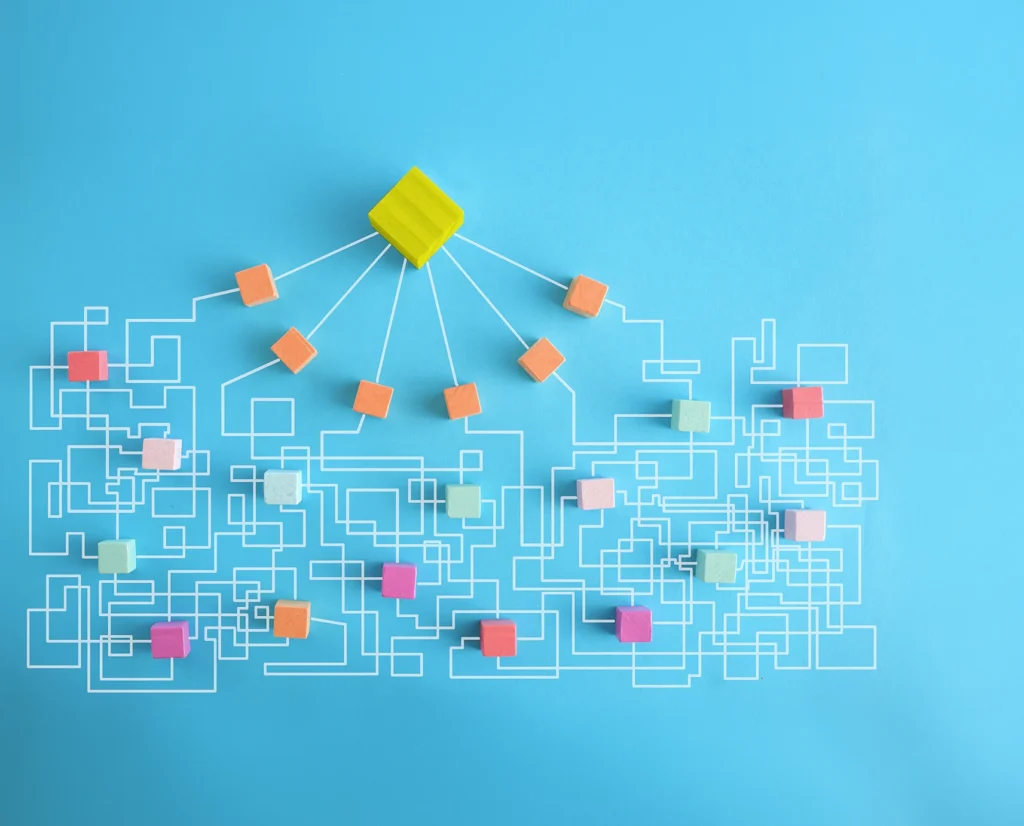 Colorful blocks connected by branching white lines on a blue background, representing the complex paths customers take when discovering and interacting with brands in the age of AI.